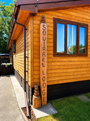 A wooden building with a sign reading 'SQUIRRELLODEG' and a squirrel statue.