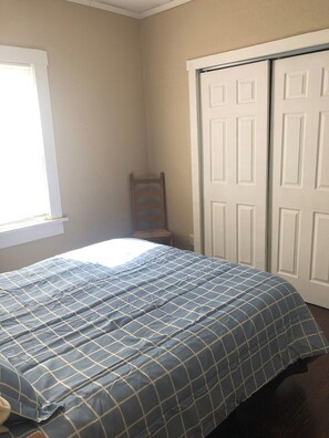 Une chambre à coucher avec un lit, une chaise et une armoire.