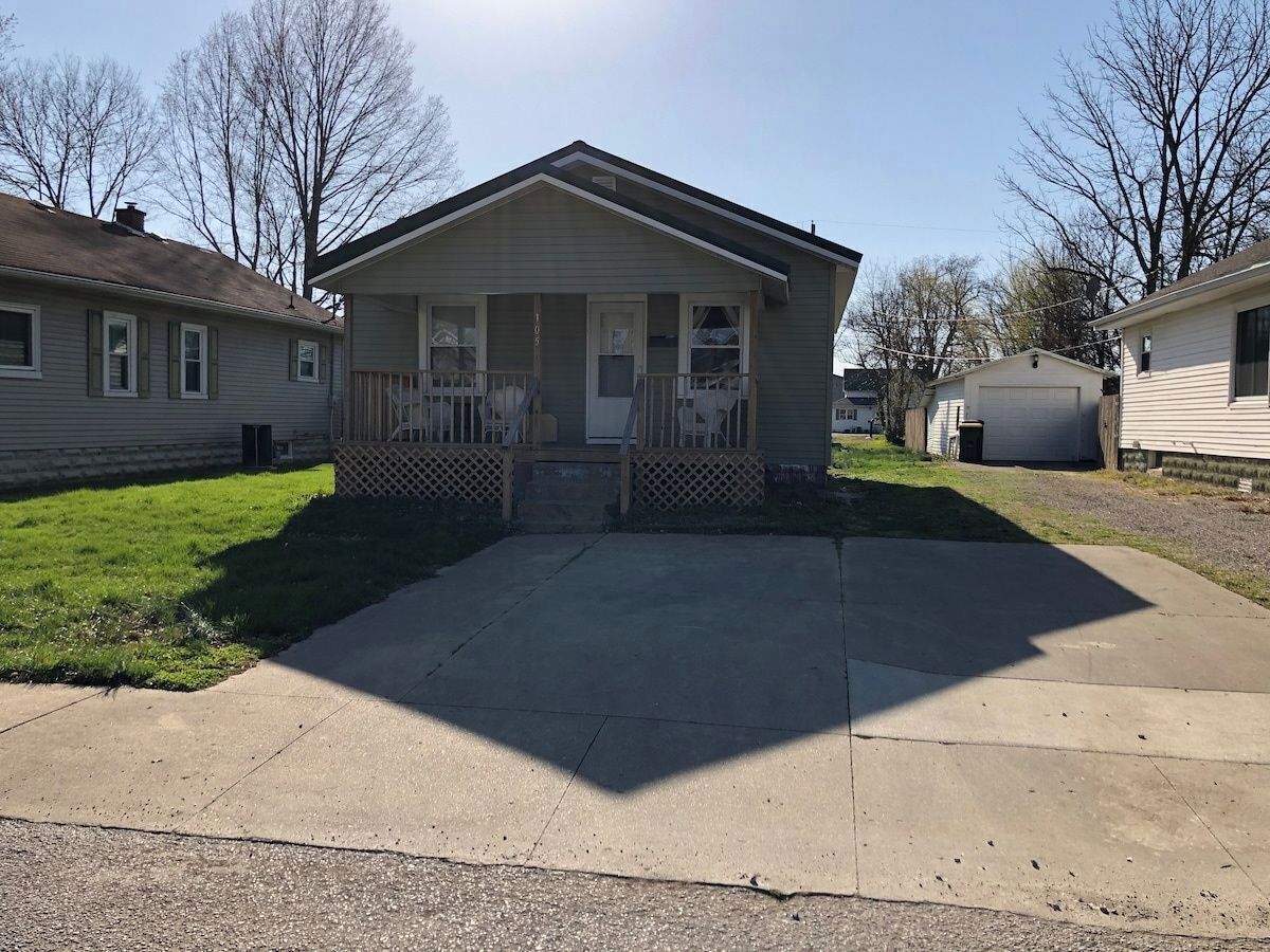 A single-story house with a front porch, a garage, and a driveway.