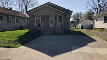 A single-story house with a front porch, a garage, and a driveway.