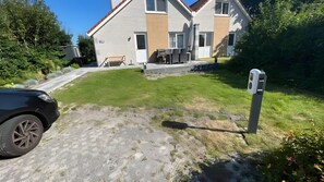 A residential property with a paved driveway, a lawn, and a house with a brick facade. - Holiday Home 'Ferienhaus Für 6 Personen 100 M² In' with Private Terrace, Private Garden and Wi-Fi (Makkum)