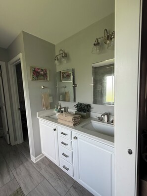 A bathroom with a double sink, a large mirror, and a towel rack. - Charming 4-bedroom house with AC in cozy Alabaster (Alabaster)