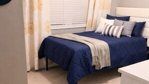 A bedroom with a bed, curtains, a bedside table, and a carpeted floor. - Charming 4-bedroom house with AC in cozy Alabaster (Alabaster)