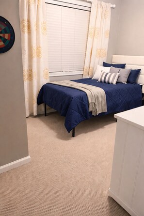 A bedroom with a bed, curtains, a bedside table, and a carpeted floor. - Charming 4-bedroom house with AC in cozy Alabaster (Alabaster)