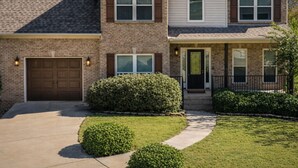 A two-story house with a brick facade, a front garage, and a well-maintained lawn. - Charming 4-bedroom house with AC in cozy Alabaster (Alabaster)