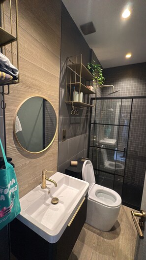 A modern bathroom with a sink, toilet, and shower. - Boho Rooms (Bristol)