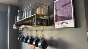 Prestatge fixat a la paret amb tasses i un mapa emmarcat de Bristol.