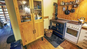 Una cocina con armarios de madera, una estufa y un lavamanos.
