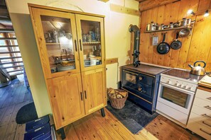 A kitchen with wooden cabinets, a stove, and a sink. - Eco-friendly farmhouse with a garden by the river (Zehrental)