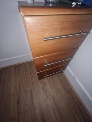 A wooden dresser with drawers and a metal handle.