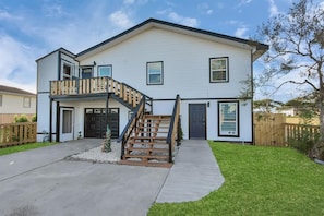 Ein zweigeschossiges Haus mit Veranda, Treppe und Garage.