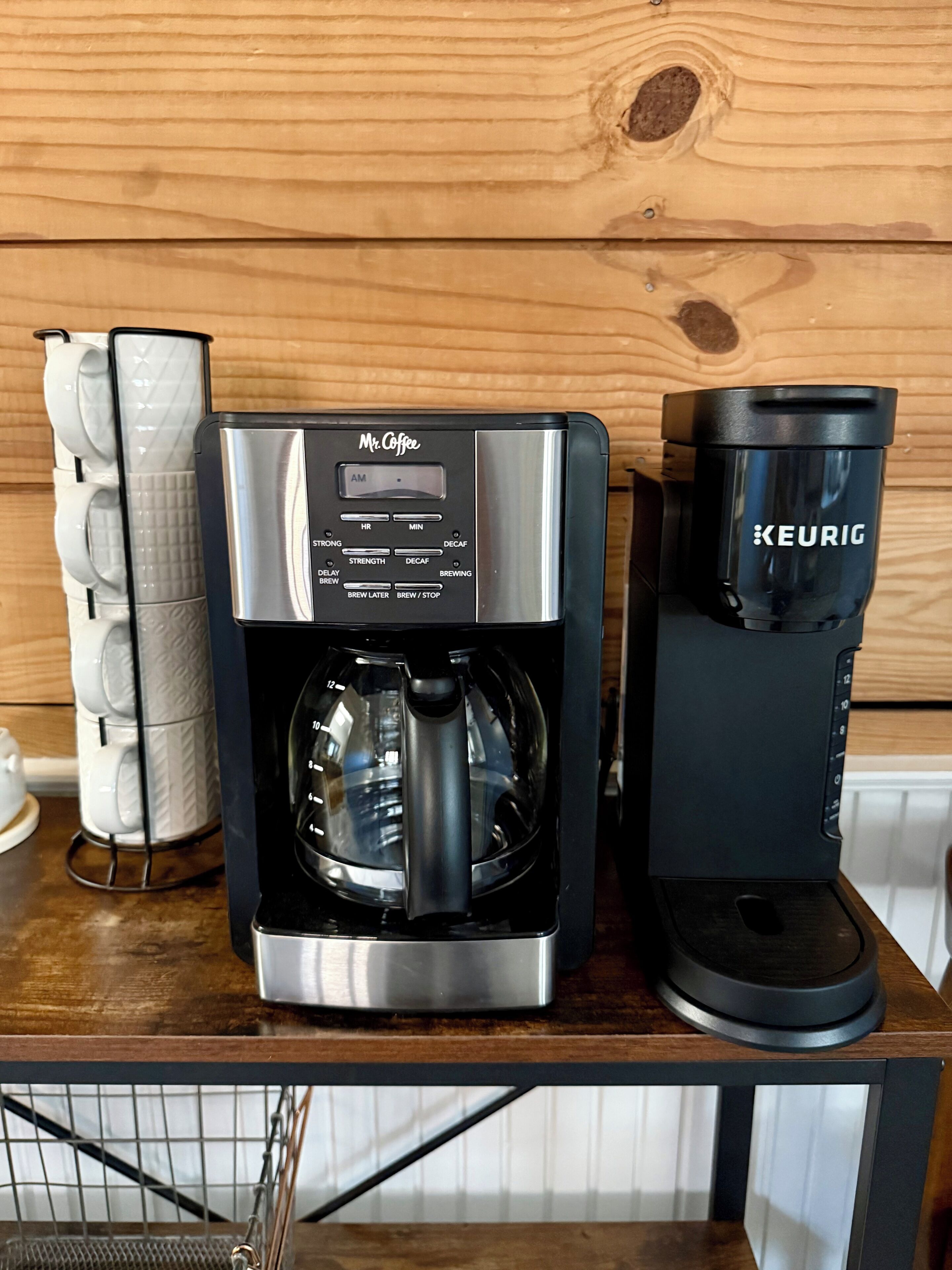 Une machine à café dotée d’un écran numérique, une cafetière et une machine Keurig, le tout posé sur une surface en bois.