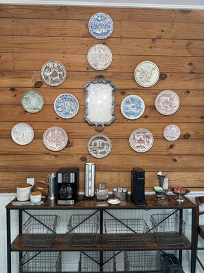 Una cocina con una pared de madera decorada con platos, una cafetera y un hervidor.