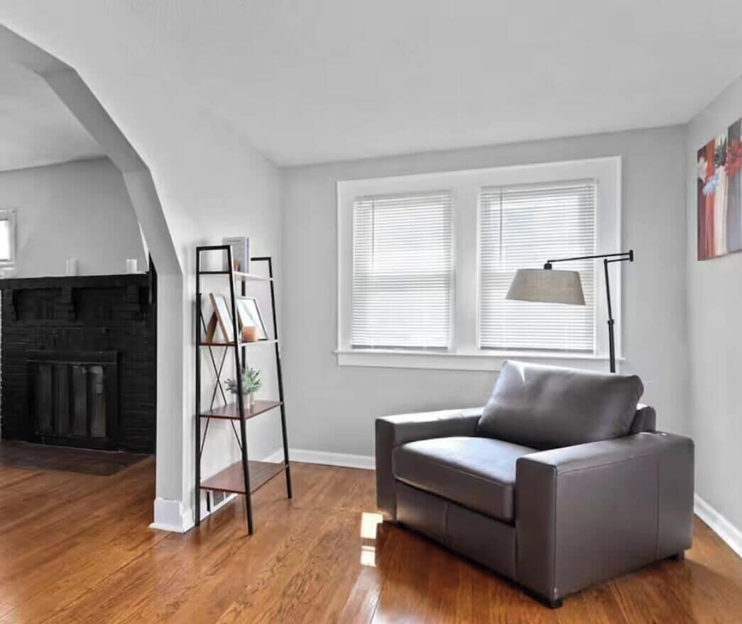 A living room with a gray sofa, a black fireplace, and a white ceiling.