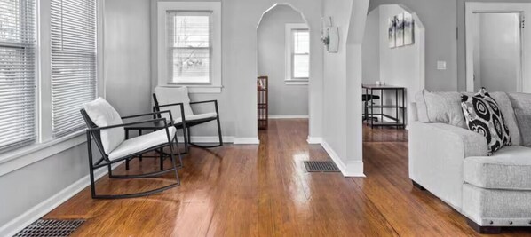 A living room with a sofa, chairs, and a dining area with a table and chairs.