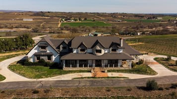 A large, two-story house with a stone foundation and a wrap-around porch.
