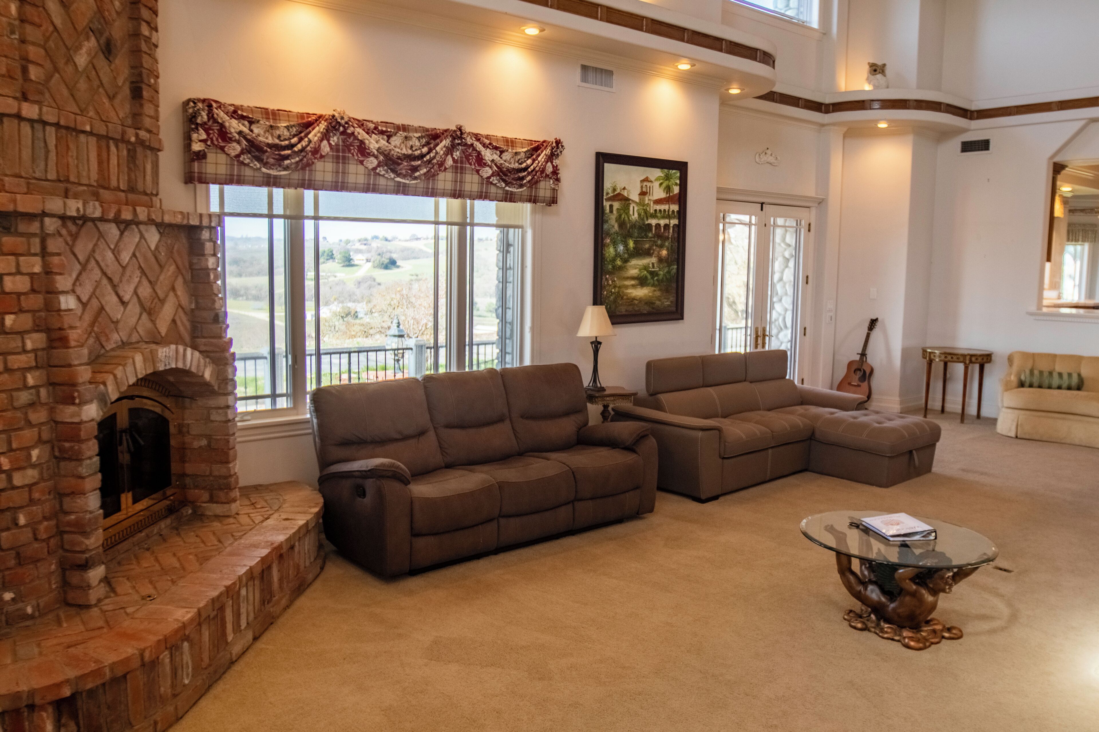 A living room with a fireplace, two sofas, a coffee table, and a painting.
