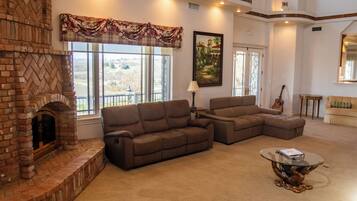 A living room with a fireplace, two sofas, a coffee table, and a painting.