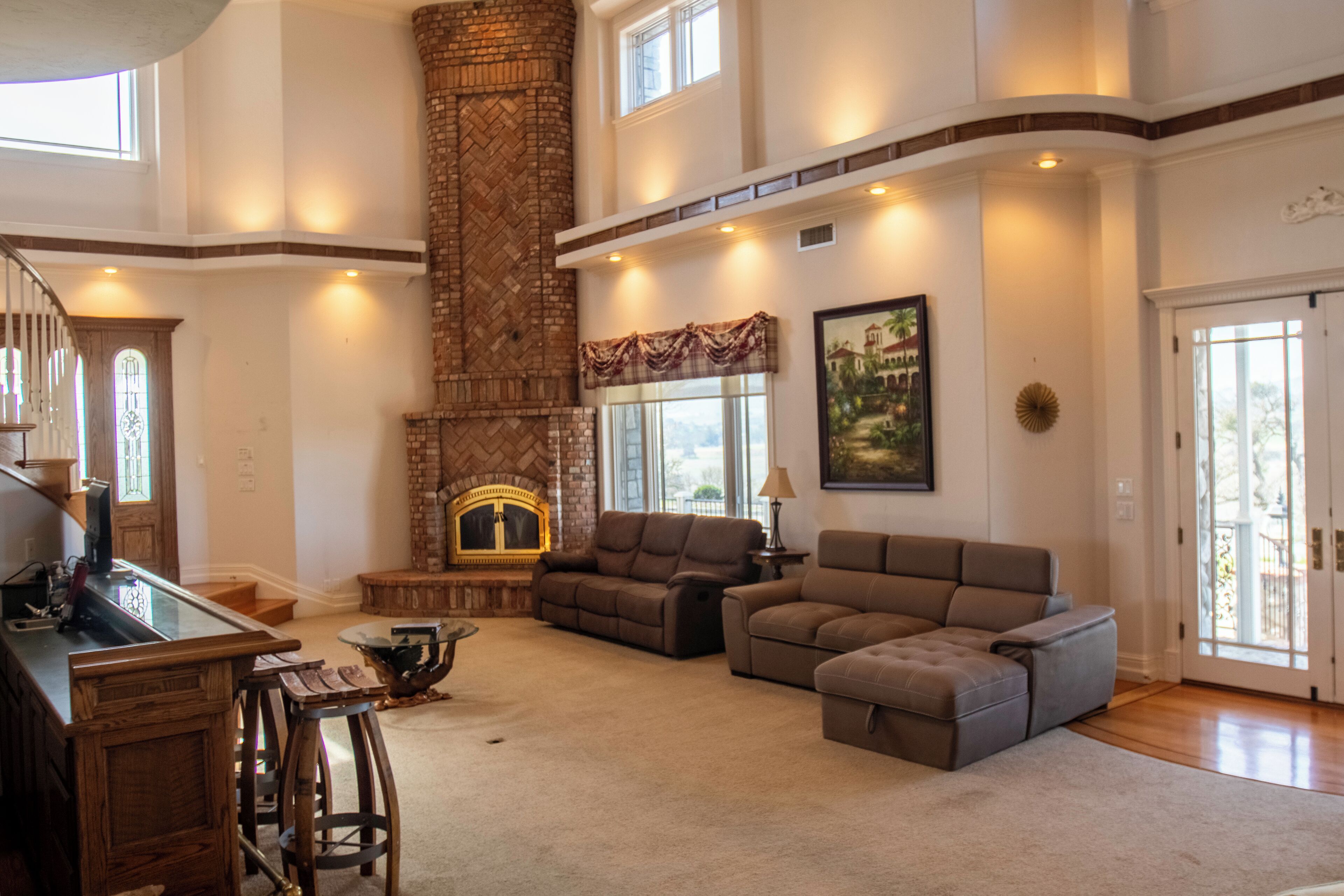 Un salon spacieux doté d’une cheminée, de sièges confortables et offrant une vue sur l’extérieur.