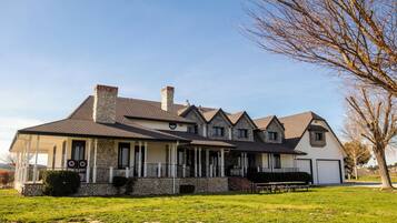 A two-story house with a stone chimney, a covered porch, and a garage.