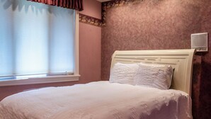 A bedroom with a bed, a window with blinds, and a wall-mounted air conditioner. - Santellan Manor (Paso Robles)