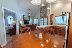 A spacious kitchen with a dining area, wooden cabinets, and a large island. - San Antonio Estate (Atascadero)