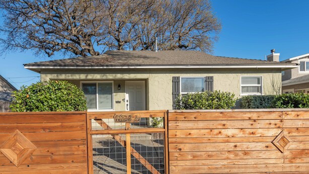 A single-story house with a front door, a garage door, and a wooden fence with a gate. - Park Street Apartment - Front Unit (Paso Robles)