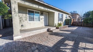 A residential house with a brick driveway, a front door, and a mailbox. - Park Street Apartment - Front Unit (Paso Robles)
