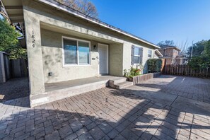 A residential house with a brick driveway, a front door, and a mailbox. - Park Street Apartment - Front Unit (Paso Robles)