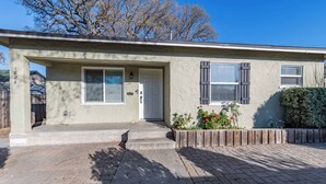 A single-story house with a front entrance, a mailbox, and a small garden with flowers. - Park Street Apartment - Front Unit (Paso Robles)