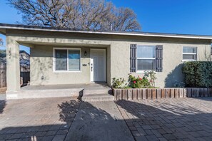 A single-story house with a front entrance, a mailbox, and a small garden with flowers. - Park Street Apartment - Front Unit (Paso Robles)
