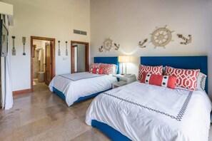 A hotel room with two beds, nautical-themed wall decor, and a hallway leading to another room. - 3-BR villa with pool and views in Puerto Bahia (Sánchez)