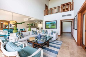 A spacious living area with a high ceiling, a dining set, and a staircase leading to an upper level. - 3-BR villa with pool and views in Puerto Bahia (Sánchez)
