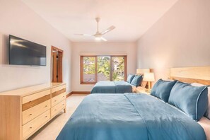 A bedroom with two beds, a TV, a ceiling fan, and a window with a view of greenery. - 3br 6 Guests  Ocean view private pool (Sánchez)
