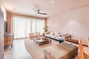 A spacious living room with a sofa, coffee table, and a TV on the left. - Apartment w 3br near the beach in Portillo Raa (Las Terrenas)