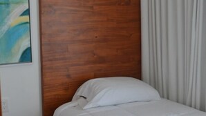 Una cama individual con cabecera de madera en una habitación de hotel.