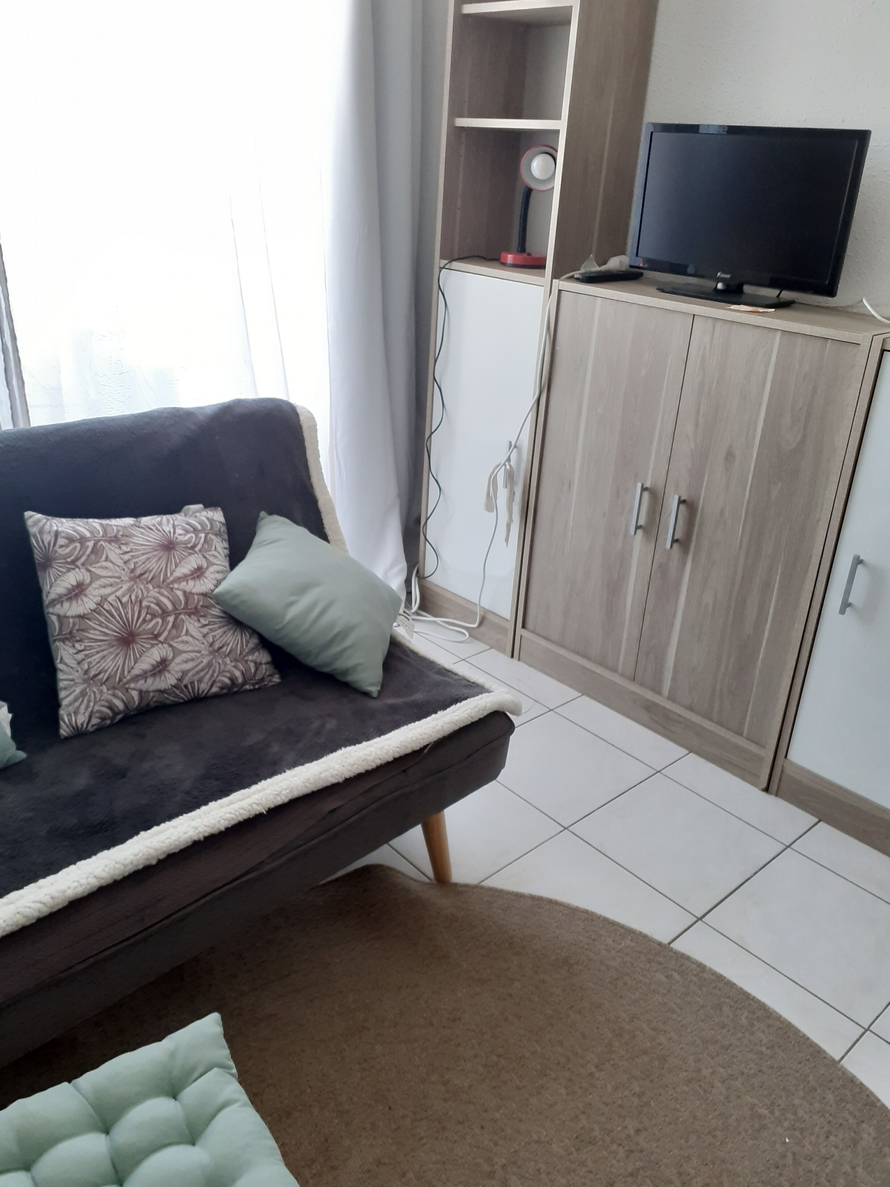 Un salon moderne avec un canapé, un téléviseur et un meuble.