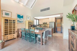 A spacious kitchen with wooden cabinets, a dining area with teal chairs, and a large island. - Family Retreat 3-Bedroom Apartment near Beach (Las Terrenas)