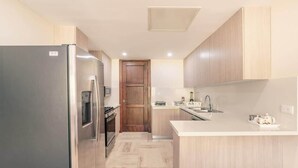 A modern kitchen with a refrigerator, stove, microwave, and sink. - Apartment with 2bedrooms in Portillo Residences (Las Terrenas)