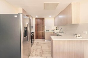 Eine moderne Küche mit Kühlschrank, Herd, Mikrowelle und Spüle.