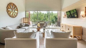 A modern living room with a sofa, chairs, a coffee table, and a television. - Apt with 2BR & balcony beach access in Portillo (Las Terrenas)