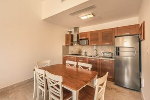 A compact kitchen with wooden cabinets, a stainless steel refrigerator, a microwave, and a gas stove. - 2br Apt 5 guests Balcony & Jacuzzi Sublime (Las Terrenas)