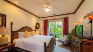 A hotel room with a bed, bedside lamps, a ceiling fan, a television, and a view of greenery outside. - Montebello 4E 3bed 3 bath (Jacó)