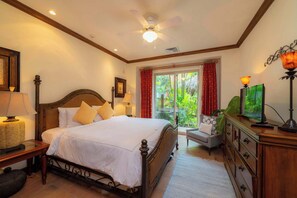 A hotel room with a bed, bedside lamps, a ceiling fan, a television, and a view of greenery outside. - Montebello 4E 3bed 3 bath (Jacó)
