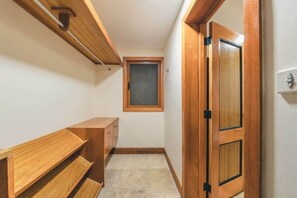 A narrow hallway with wooden flooring, a small window, a wooden bench, and a door with a black handle. - Puerto Bahia Villa Pool, BBQ & Amazing views! (Sánchez)