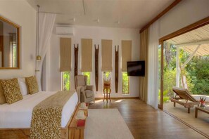 A spacious bedroom with a large bed, a television, and a view of the outdoors. - Indian Ocean Beachfront Sanctuary (Paje)