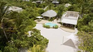 Ein Resort mit zentralem Pool, umgeben von üppiger Vegetation und Palmen.