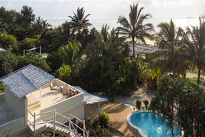 Ein Resort mit Pool, Sitzgelegenheiten im Freien und Blick auf den Ozean.