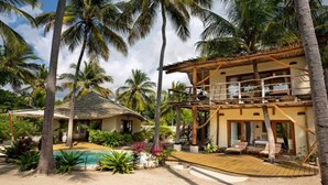 A two-story resort with a pool, palm trees, and a thatched-roof structure. - Zanzibar Family Paradise Villa (Paje)