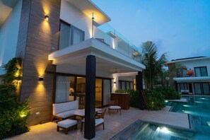 A modern two-story house with a pool, outdoor seating, and a well-lit patio area. - Direct entry pool 7 guests 2 bedrooms 2 (Monterrico)